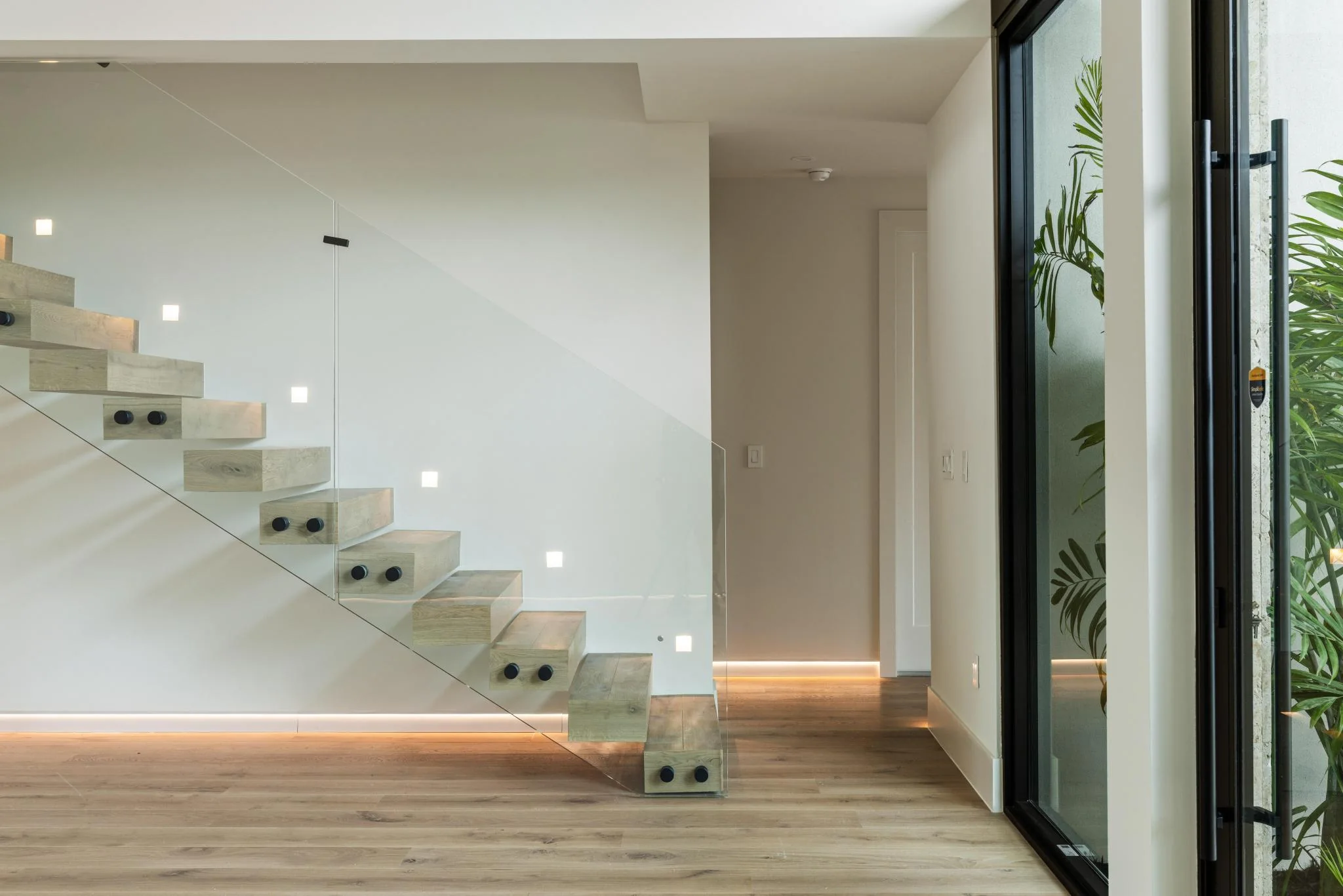 Floating stair with glass balustrade and precision lighting