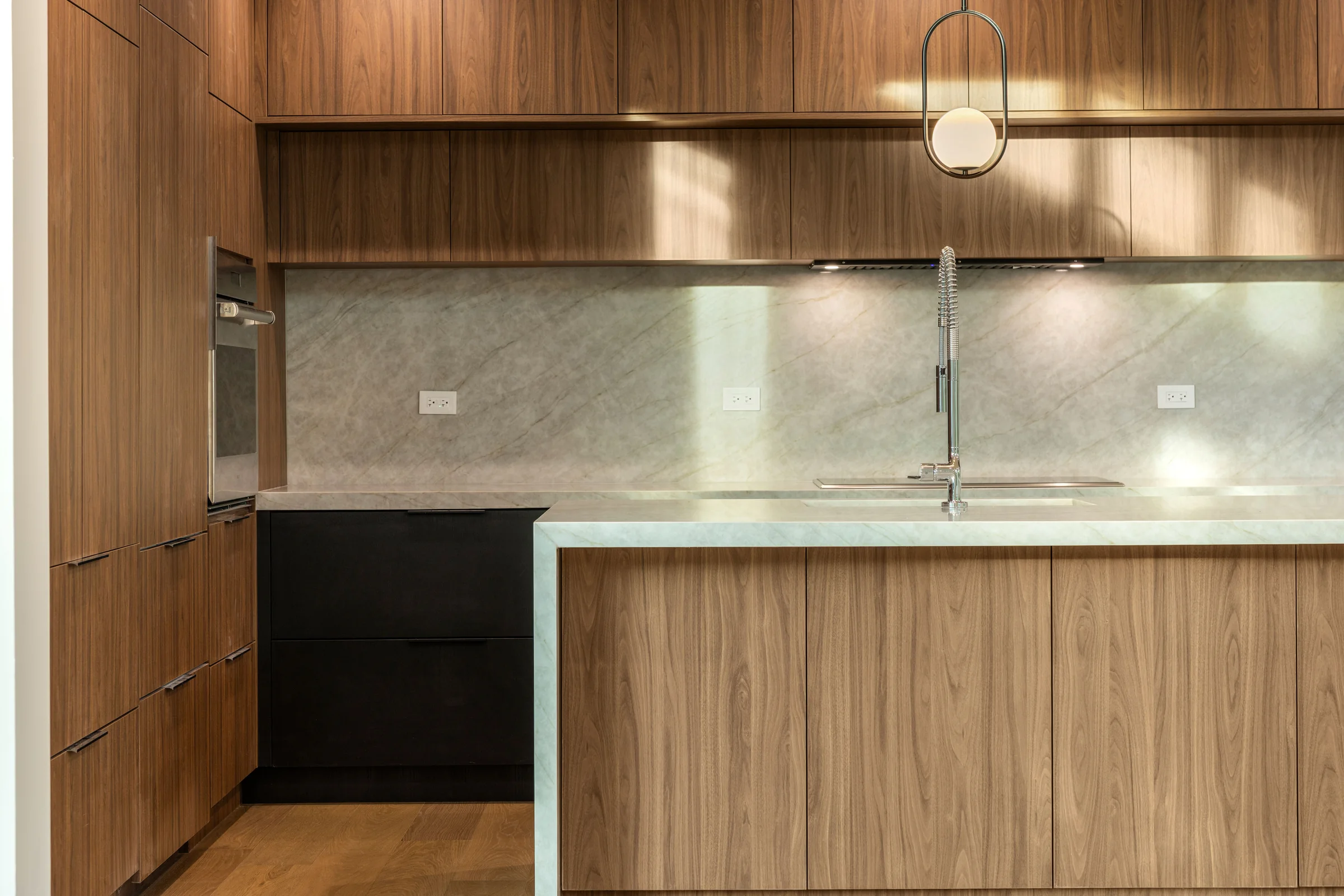 Warm wood cabinetry and stone backsplash detail
